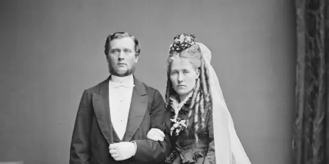 Brudpar i 1800-talets kläder, en viktig del av giftermål historia. Mannen bär frack, kvinnan slöja och blommor.
