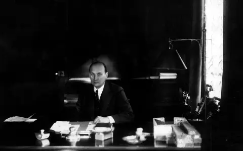 Ivar Kreuger, en svensk ingenjör och industriman, sitter vid sitt skrivbord. En scen som skulle kunna vara från en **Ivar Kreuger film**.