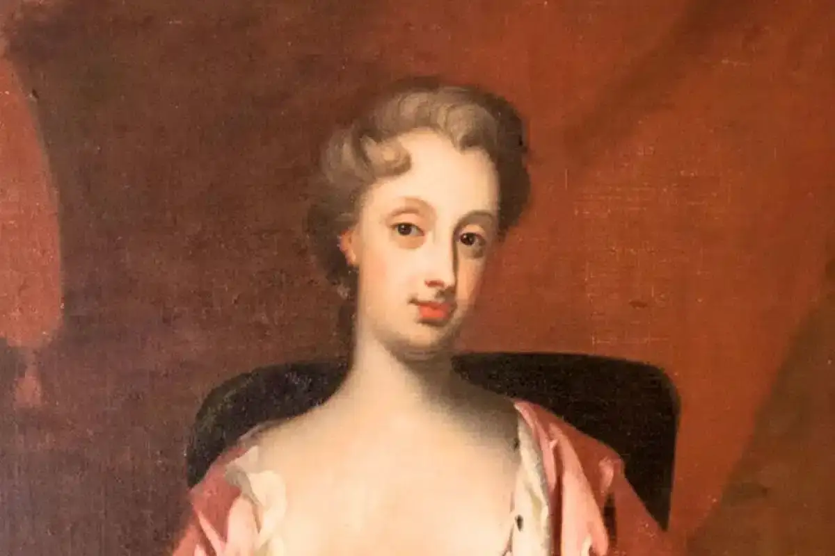 Portr&auml;tt av Christina Piper i rosa kl&auml;nning, med en mjuk blick och uppsatt h&aring;r.