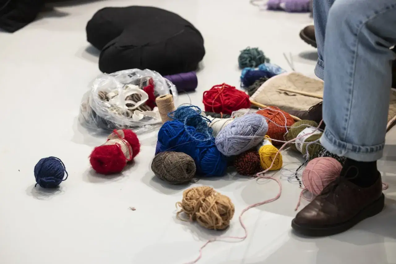 Elin Berlin sitter omgiven av garn i olika f&auml;rger och texturer, redo f&ouml;r ett kreativt projekt.