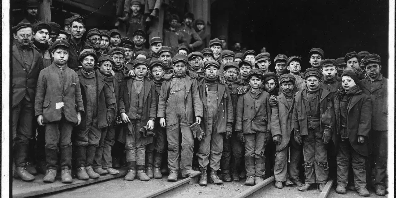 En grupp pojkar, kl&auml;dda i slitna kl&auml;der, vittnar om barnarbete under den industriella revolutionen.