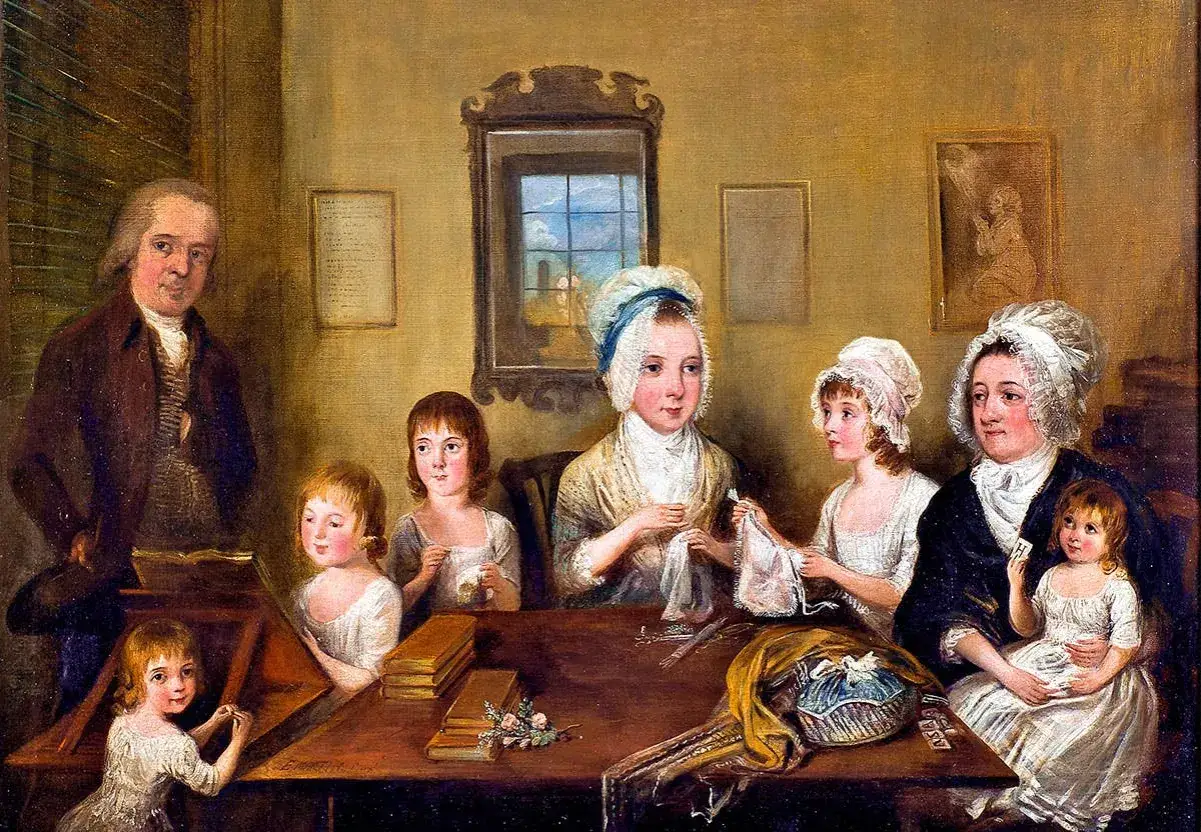 En familj samlad runt ett bord, kanske som Carl Michael Bellman barn, med en man som l&auml;ser och barn som sysslar med handarbete.