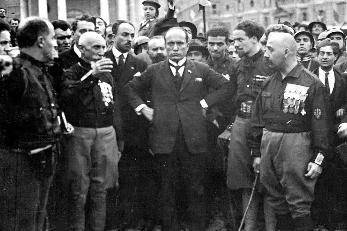 Mussolini omgiven av m&auml;n i uniform. Bilden ger en k&auml;nsla av makt och auktoritet, och visar vad fascism betyder f&ouml;r m&aring;nga.