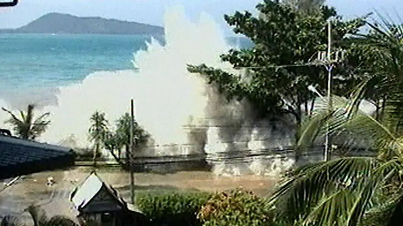 Enorm v&aring;g sl&aring;r in &ouml;ver land, palmer och byggnader. En bild som visar f&ouml;r&ouml;delsen efter tsunamin 2004.