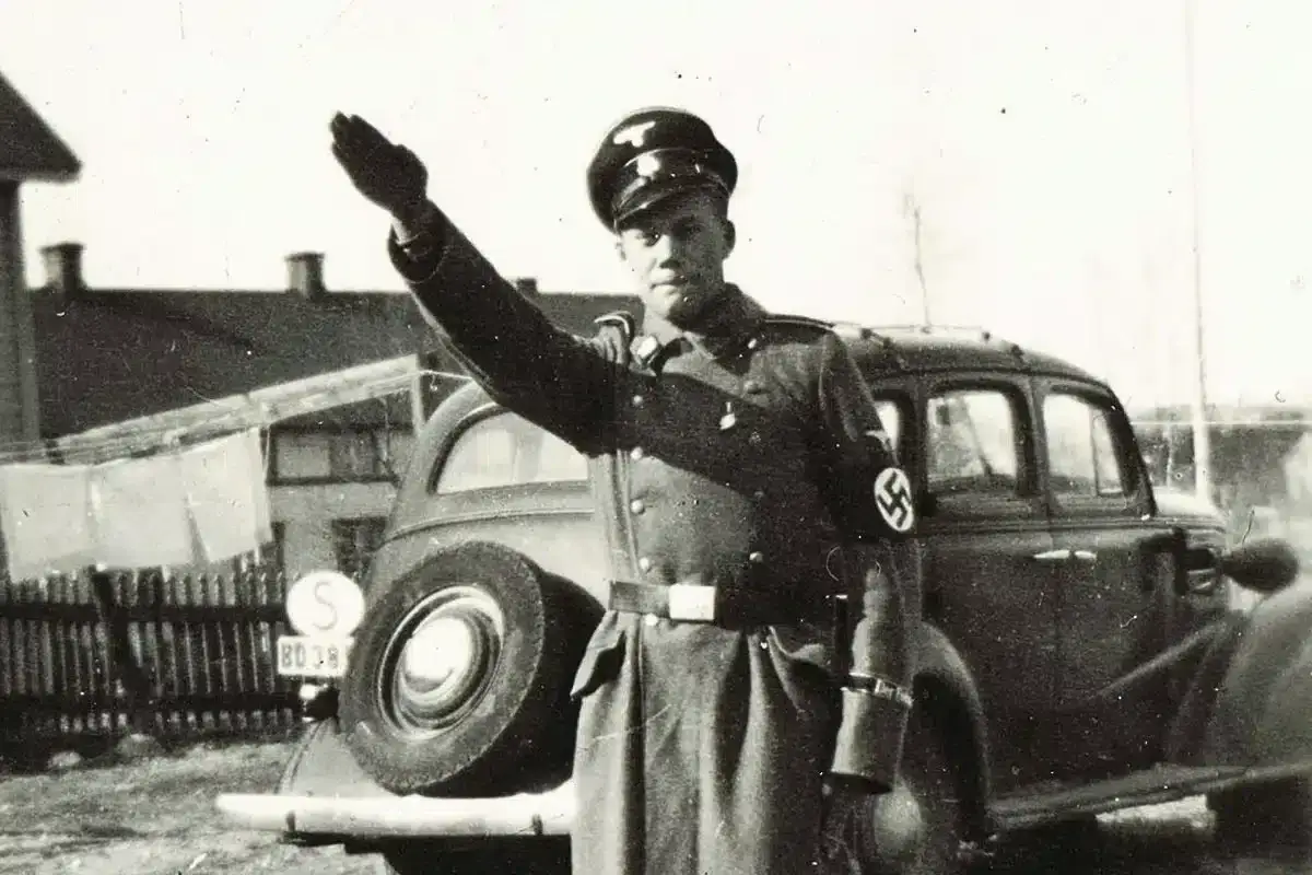 En man i uniform med hakkors h&auml;lsar. Bilden visar en historisk scen med svenska nazister.