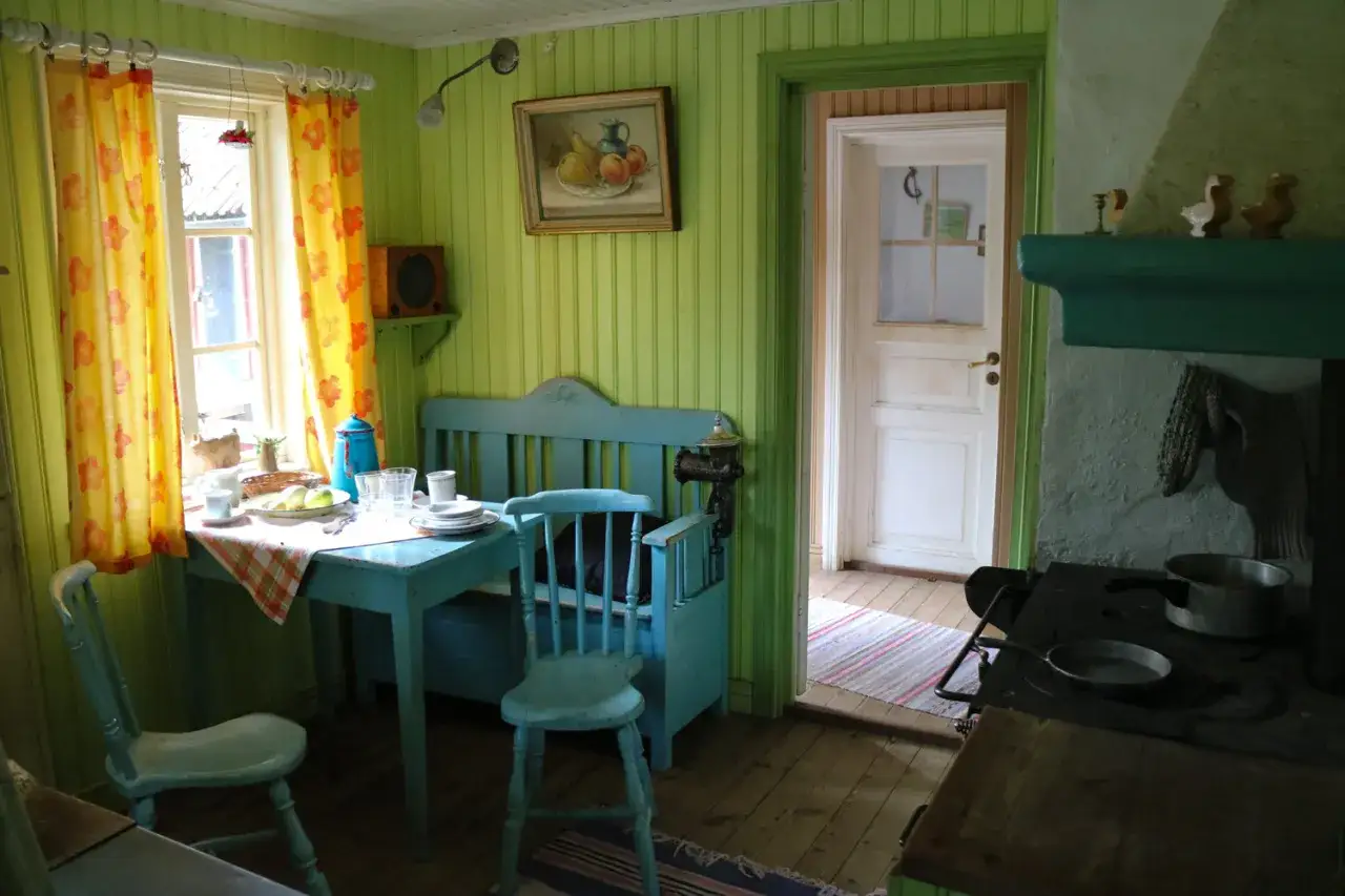 Julita g&aring;rd, Pettson och Findus k&ouml;k. Ett charmigt k&ouml;k med ljusgr&ouml;na v&auml;ggar, bl&aring; m&ouml;bler och en &ouml;ppen d&ouml;rr.